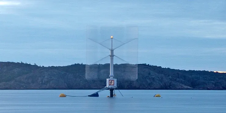 The SeaTwirl S1 prototype in operation off a wooded shore, with buoys around the turbine