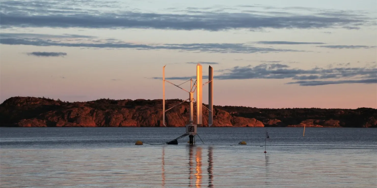 Prototypen SeaTwirl S1 i solnedgång med ett klippigt skär bakom och orange ljus över vattnet