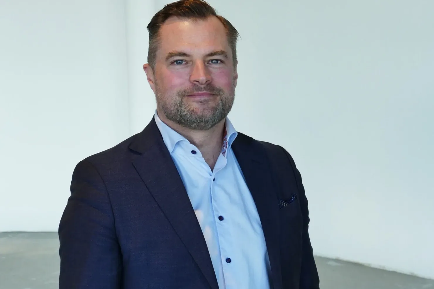 Johan Sandberg in a dark blue jacket and a light shirt, photographed indoors